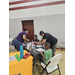 A group of teachers assisting children in painting.