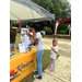 A young lady at the Kinston Housing table rolling dice to get prizes.