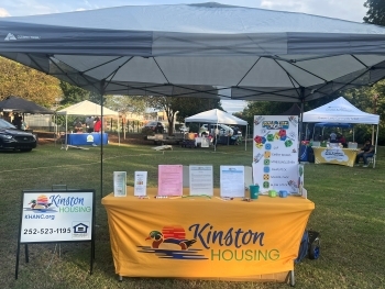 Information on a Kinston Housing table outside.