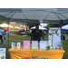 A  lady behind a table outside with information about Kinston Housing.